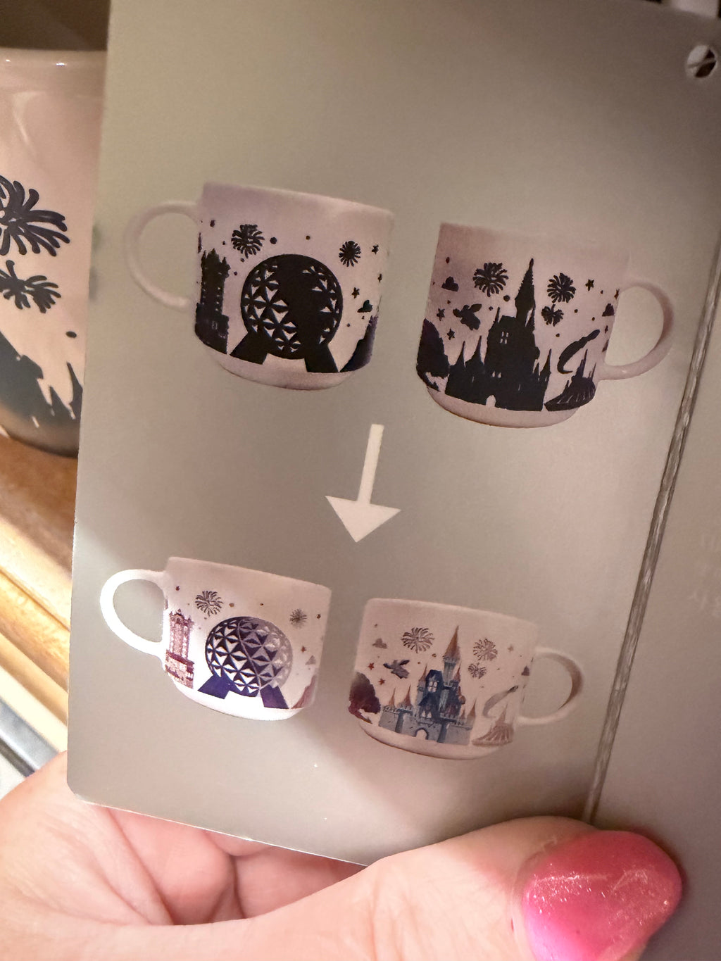 Card with cut-out mug shapes featuring different designs, held by a hand.