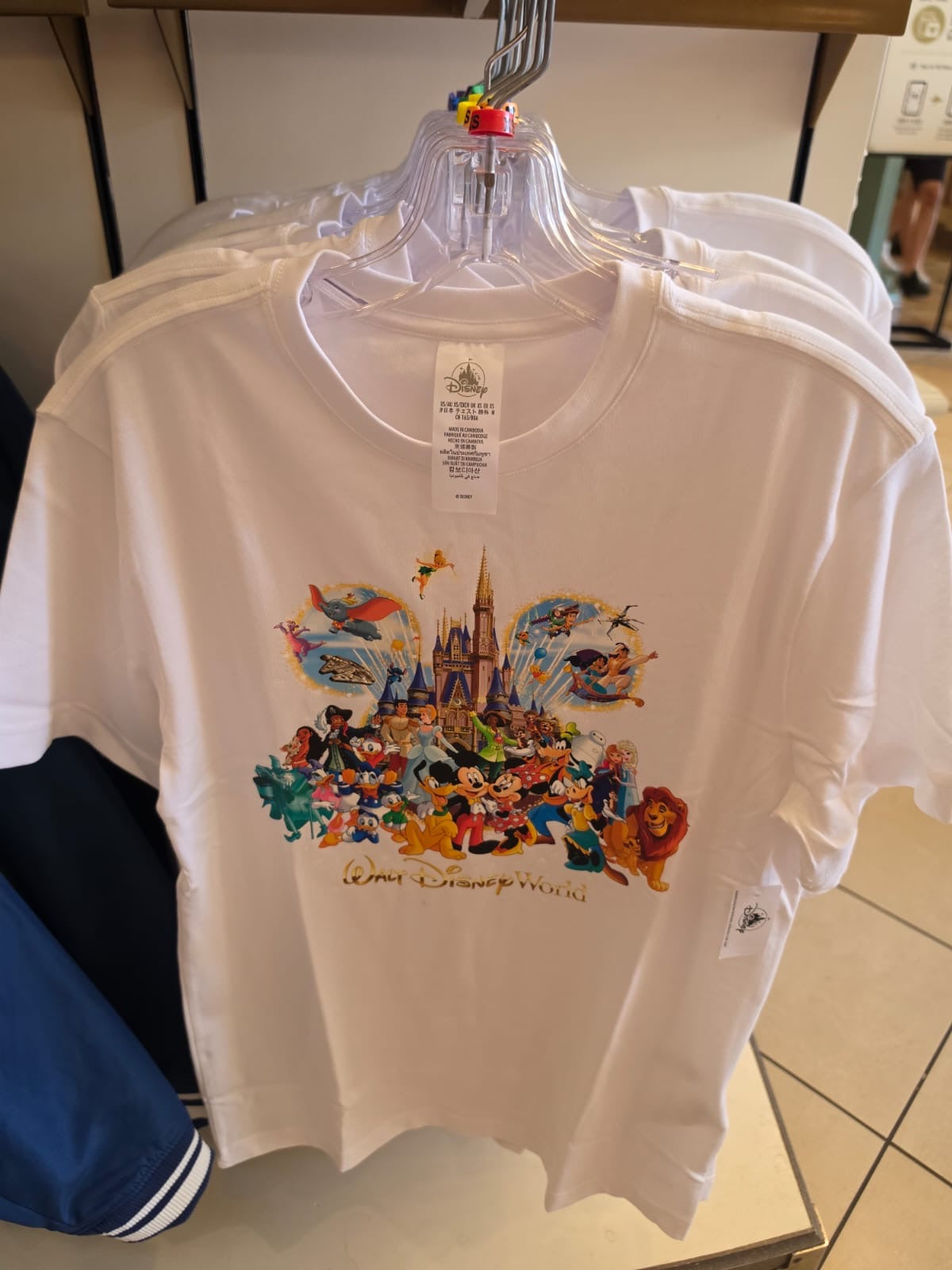 White t-shirt with colorful Disney character design on a hanger.