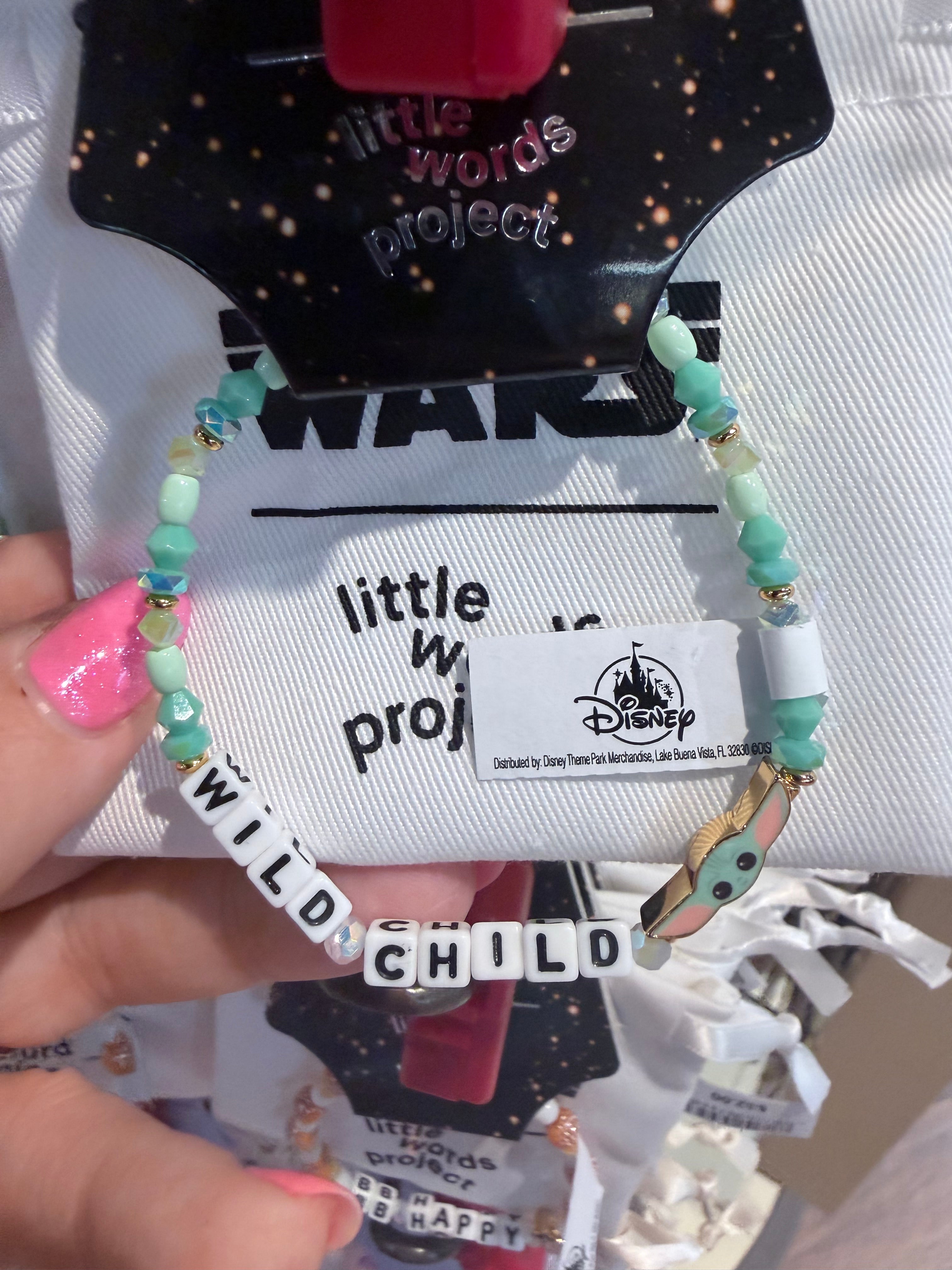 Bracelet with 'wild child' beads held against a branded background