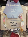Bracelet with letter beads and Disney Parks tag on a beige cushion
