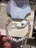 Bracelets with 'little words project' and 'Disney Parks' branding on a textured surface.
