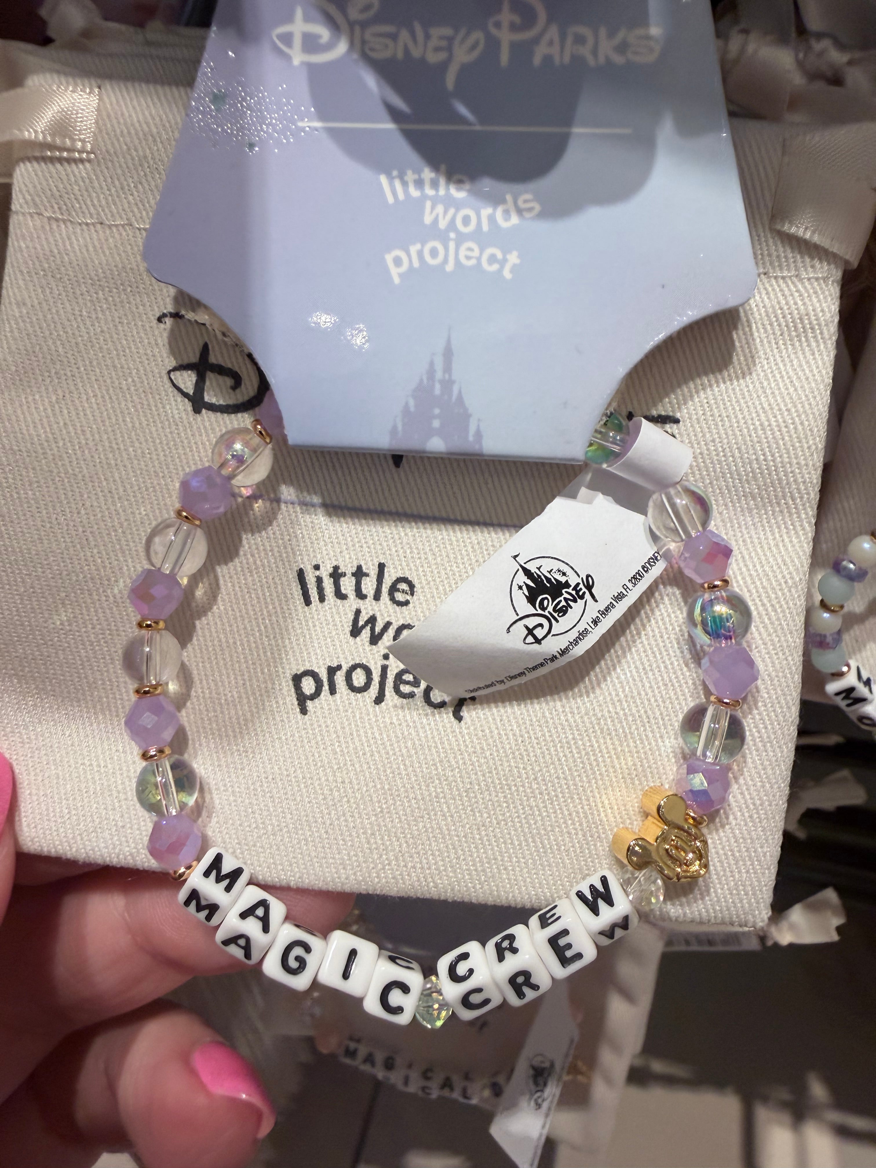 Bracelets with 'little words project' and 'Disney Parks' branding on a textured surface.